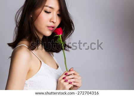 Portrait of asian young woman with red rose flower