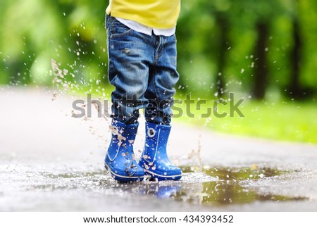 Toddler jumping in pool of water at the summer or autumn day