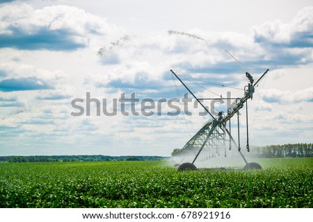 Watering system in the field. An irrigation pivot watering a field