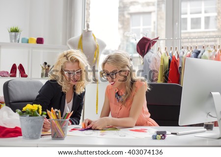 Two creative fashion designers looking at sketch