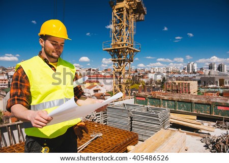 Construction worker checking blueprints on site