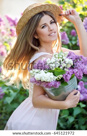 https://thumb9.shutterstock.com/display_pic_with_logo/743137/645121972/stock-photo-young-woman-in-straw-hat-woman-with-lilac-flowers-in-springtime-gardening-645121972.jpg
