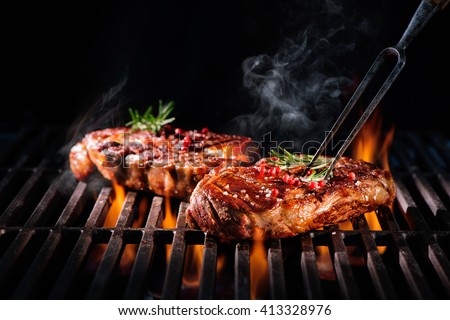 Beef steaks on the grill with flames