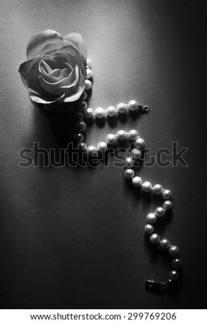 soap rose and pearl necklace on white background in black and white