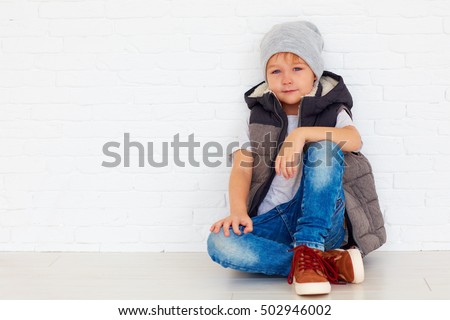 portrait of fashionable kid near the wall