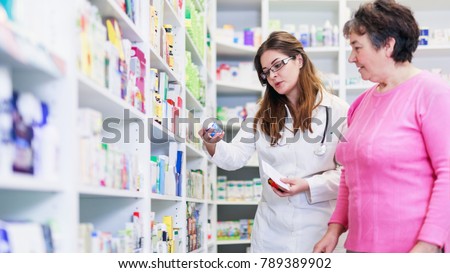 Female pharmacist discusses prescription medication with senior customer at pharmacy