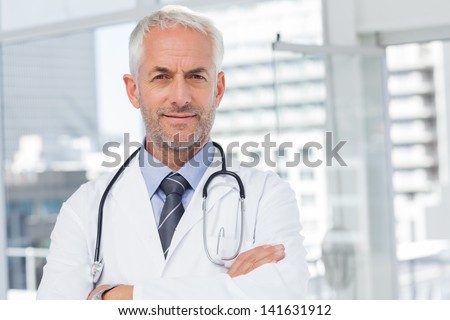 Doctor with stethoscope around his neck looking at the camera