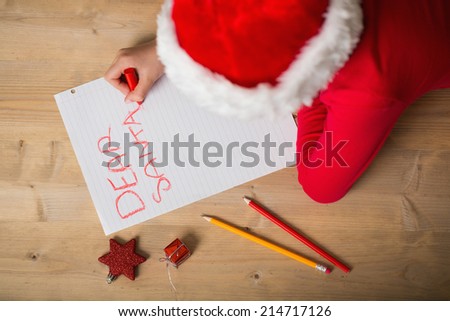 Little girl writing letter to santa at christmas at home in the living room