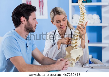 Physiotherapist explaining the spine model to patient in the clinic