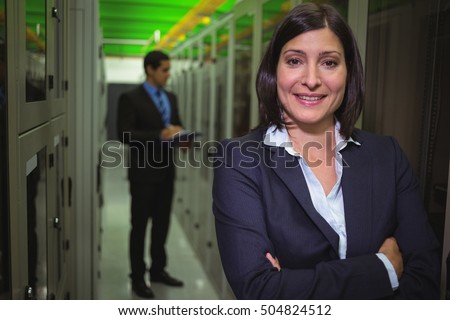 Portrait of female technician standing with arms crossed in server room