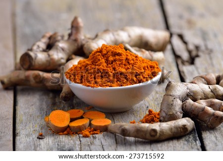 fresh turmeric roots on wooden table