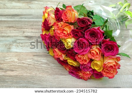 bouquet of fresh roses on a wooden background close-up. horizontal photo. - stock photo