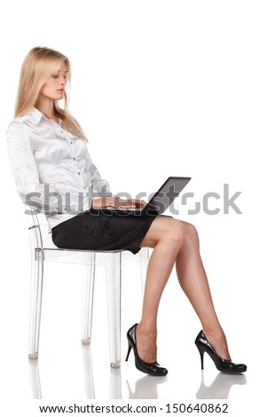 Young woman with a laptop sitting in full length isolated on white background