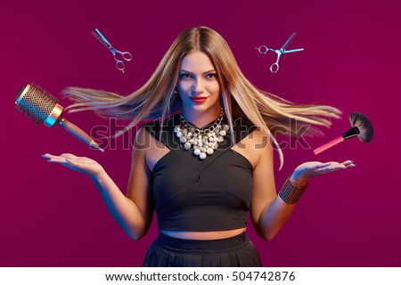 Glamourous female stylist with fluttering hair and flying hairdresser's accessories