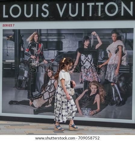 TOKYO, JAPAN - SEPTEMBER 1ST, 2017. Woman walking in front of Louis Vuitton outlet at Tokyo Station.