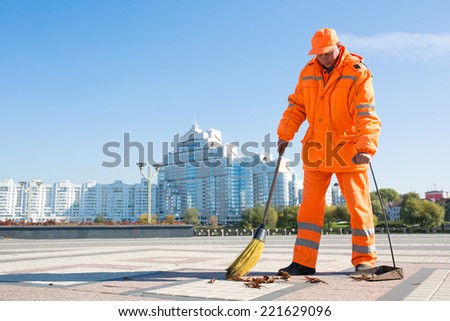 Man road sweeper caretaker cleaning city street with broom tool