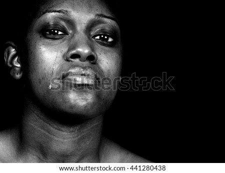 Black and white portrait of a tearful african american woman posing against a black background Black and white portrait of a tearful african american woman posing against a black background