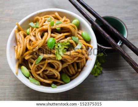 A spicy Asian noodle dish with chopsticks.