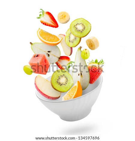 Assorted fresh fruits flying in a bowl/ Light salad with flying fresh fruits