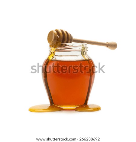 Pot of honey with wooden drizzler on white background