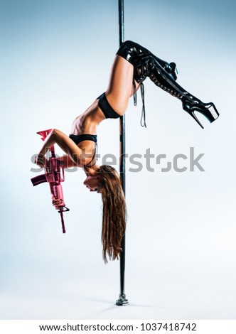 stock-photo-young-slim-sexy-woman-in-black-leather-clothing-with-pink-gun-pole-dancing-1037418742.jpg