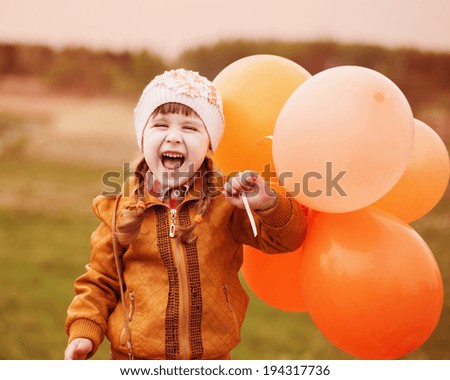 happy girl with orange balloons outdoor
