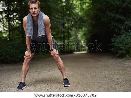 Fit Young Man Holding his Knees While Resting After a Running Exercise ...