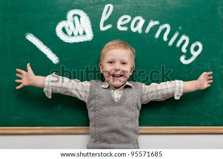 Cheerful smiling child at the blackboard. School concept