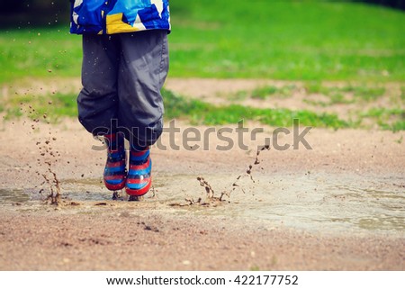 child playing in muddy puddle