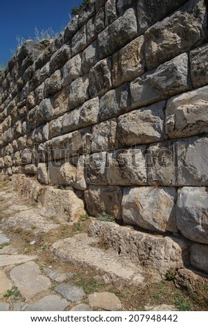 Massive ashlar masonry wall along a street near the agora of the ...