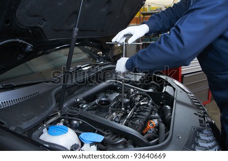 mechanic repairs a car in a garage