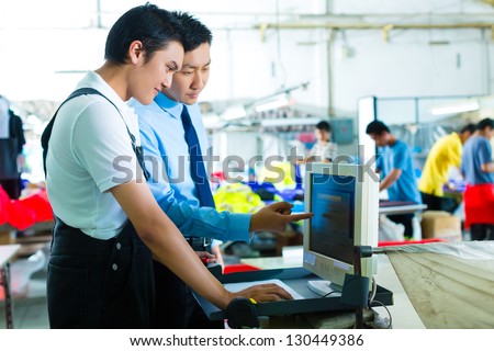 Worker is new assigned to a machine in a textile factory, the foreman explains something