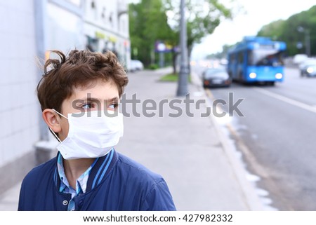 preteen handsome boy in protective mask on the urban background