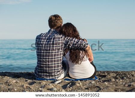 https://thumb9.shutterstock.com/display_pic_with_logo/848425/145891052/stock-photo-young-couple-sitting-together-on-beach-145891052.jpg
