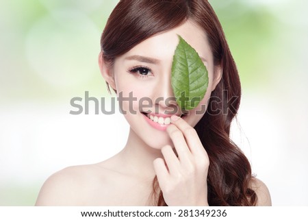 beautiful woman face portrait with green leaf , concept for skin care or organic cosmetics , asian beauty