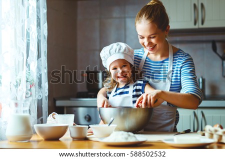 happy family in the kitchen. mother and child daughter preparing the dough, bake cookies