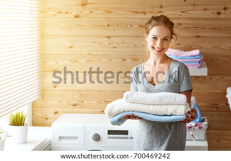 a Happy housewife woman in laundry room with washing machine