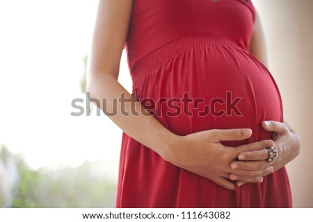 Image of pregnant woman touching her belly with hands