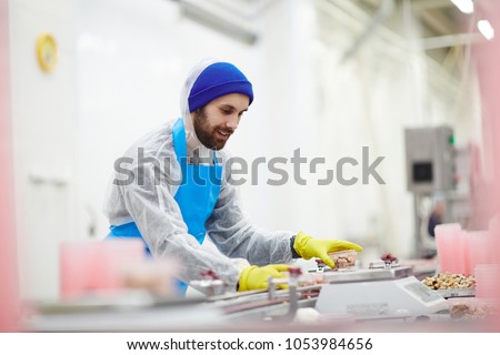 Fish factory staff weighing plastic containers with processed mussels befor epacking
