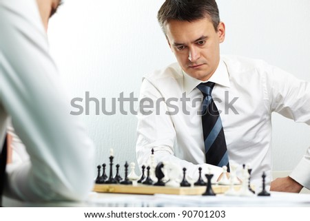Image of businessman thinking while playing chess