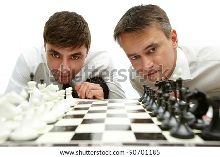 Two men looking at chess figures on chess board
