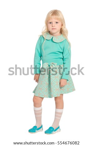 Caucasian young blond girl in light green dress standing isolated on white