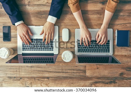 man and woman working on their computers. the view from the top. two laptops, two persons.