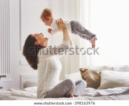 happy loving family. mother playing with her baby in the bedroom.