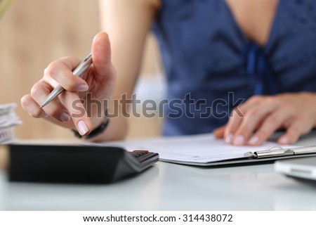 Close up of female accountant or banker making calculations. Savings, finances and economy concept