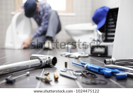 plumber at work in a bathroom, plumbing repair service, assemble and install concept