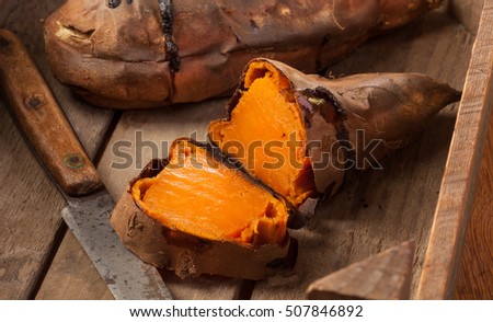 Oven baked sweet potatoes on vintage wood.