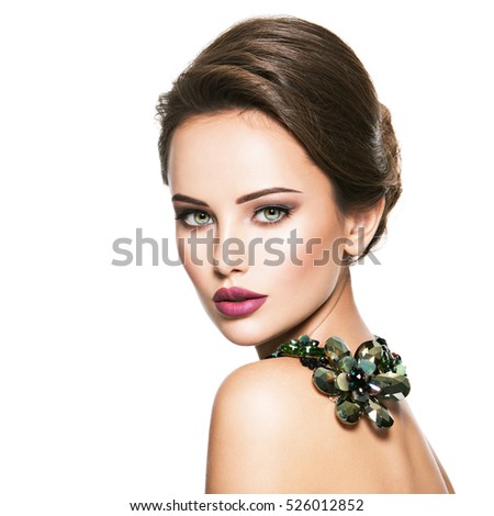 Beautiful woman with fashionable jewelry. Portrait of a pretty fashion girl with green glass necklace. American Model posing over white background