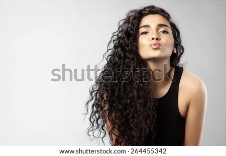 Real woman with beauty black hair gives a kiss