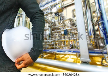 engineer suit white helmet for security stood on the details of Industrial equipment stainless